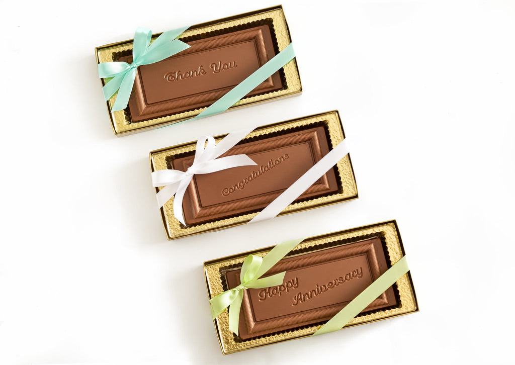 Chocolate plaques in gold boxes tied with ribbons